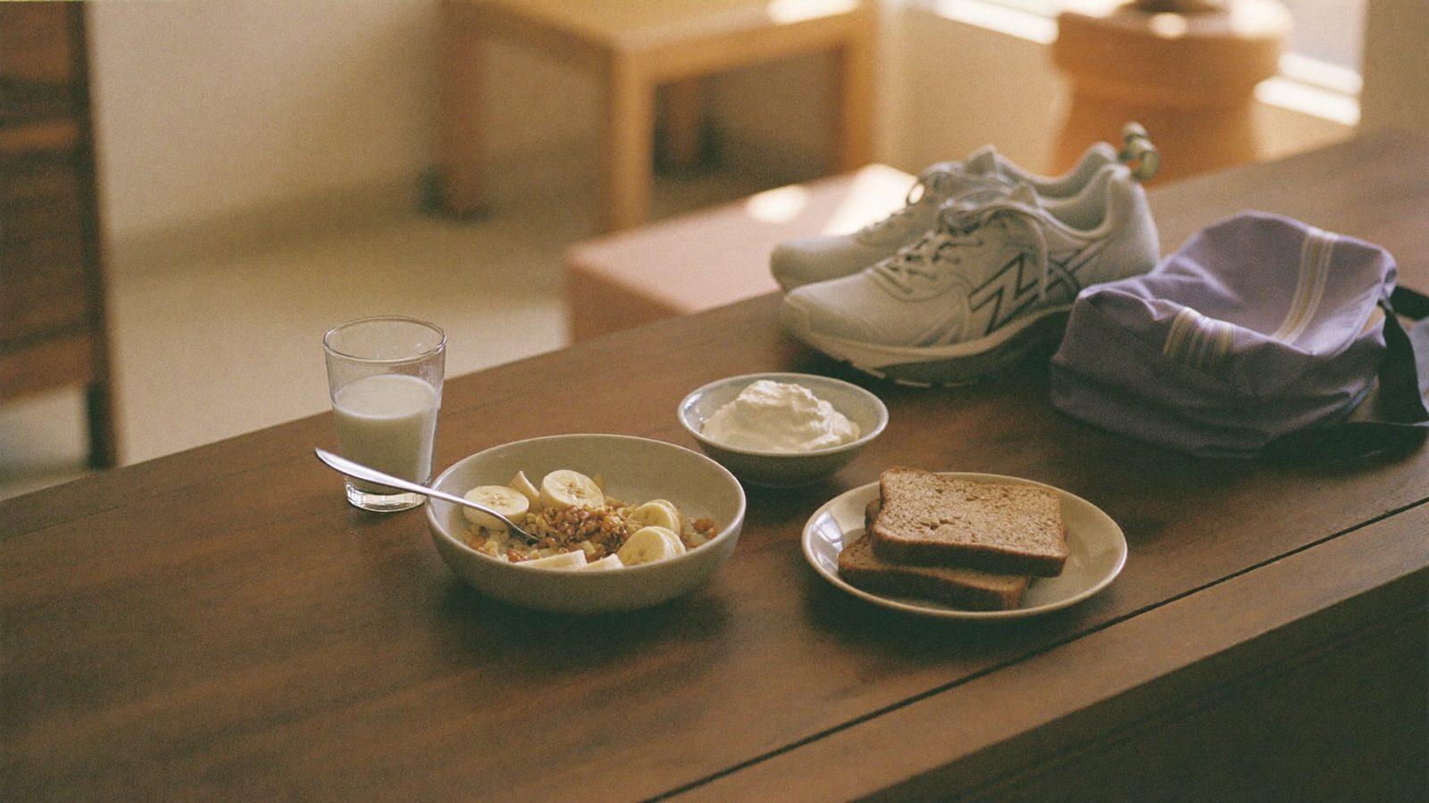 Desayuno con avena, plátano y yogur junto a unas zapatillas de deporte