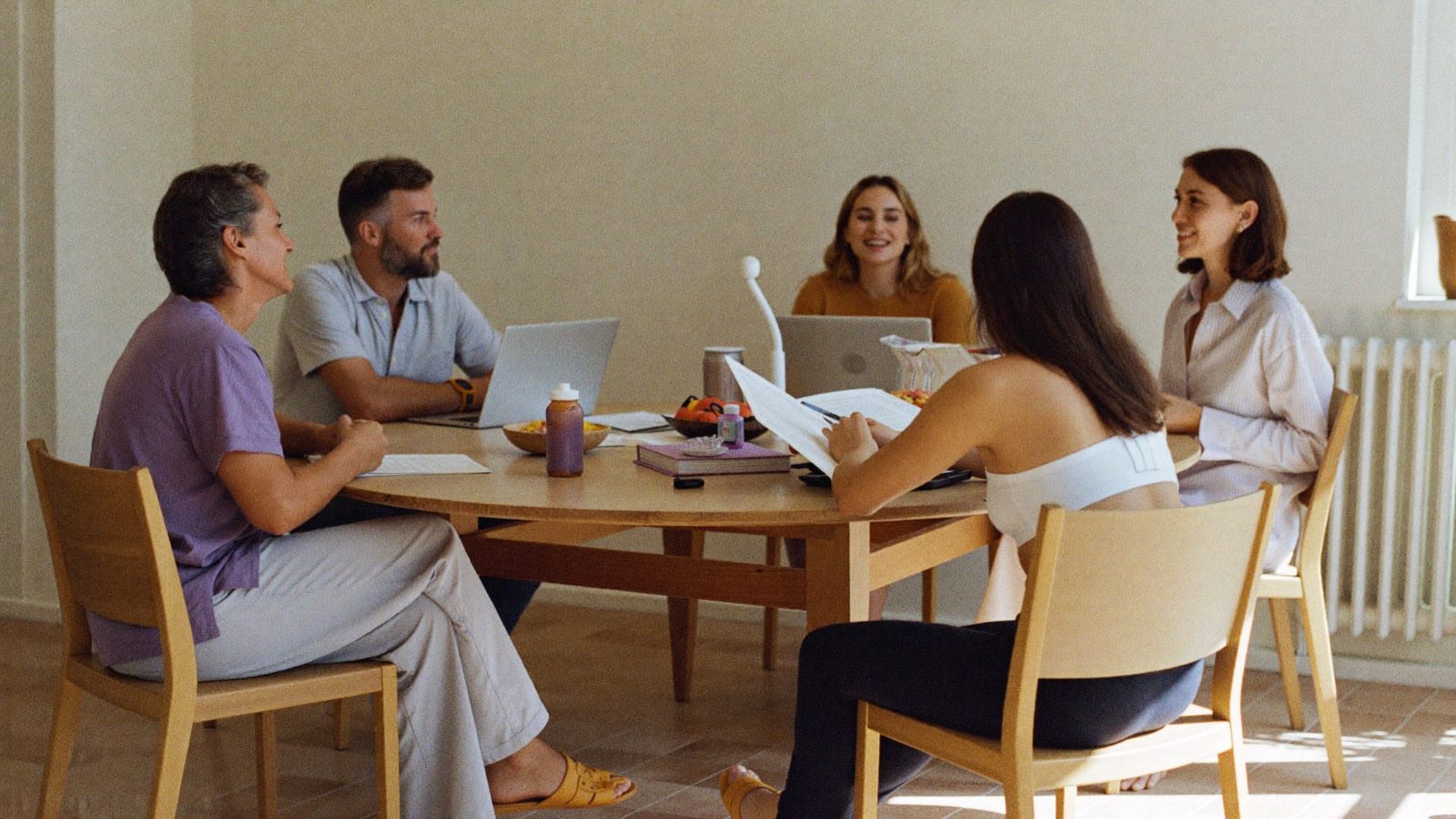 Equipo de profesionales de la salud conversando alrededor de una mesa en el centro