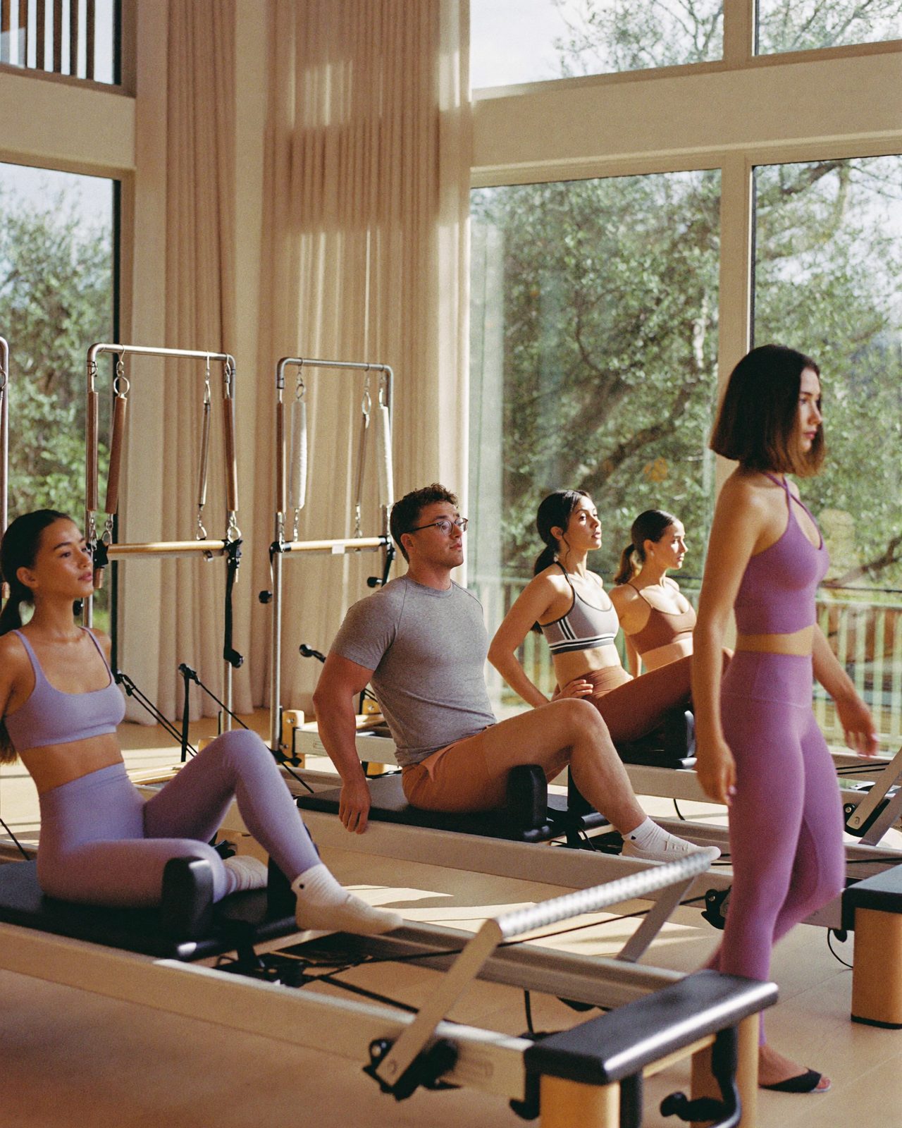 Clase de pilates reformer en grupo reducido en un estudio luminoso